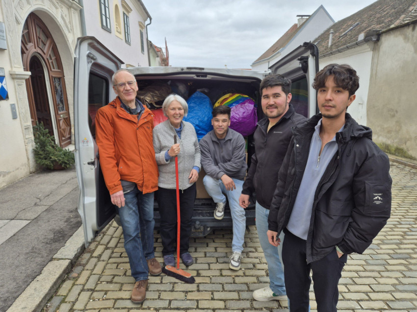 Az osztrák közösség tagjai az adományokkal teli kisbusz mellett