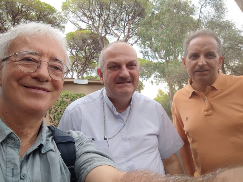 Mourad atya középen; bal oldalon a cikk szerzője, Maurizio Certini; jobb oldalon pedig Gabriele Pecchioli, az Opera per la Gioventù La Pira Foro FGLP szervezet elnöke2026 augusztusában